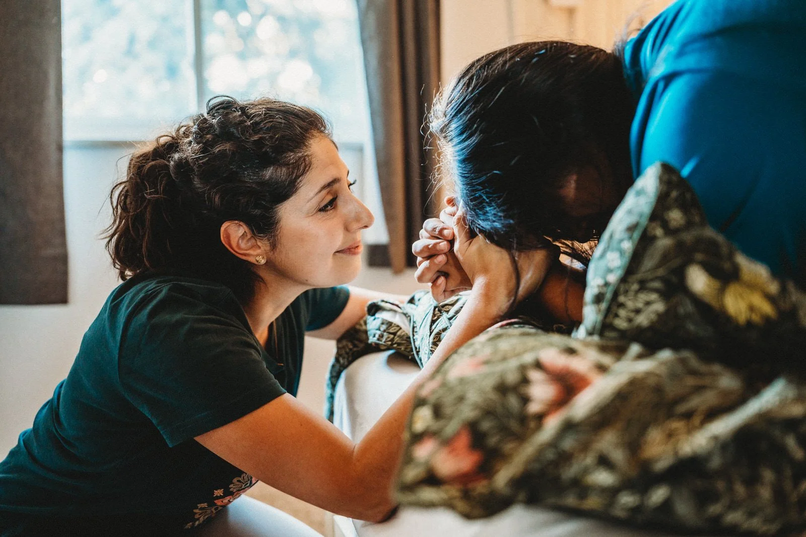 Maribel comforting a laboring mother face to face
