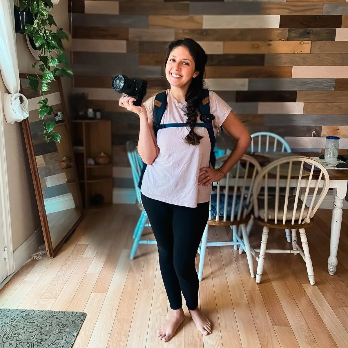 Maribel smiling warmly, holding her camera