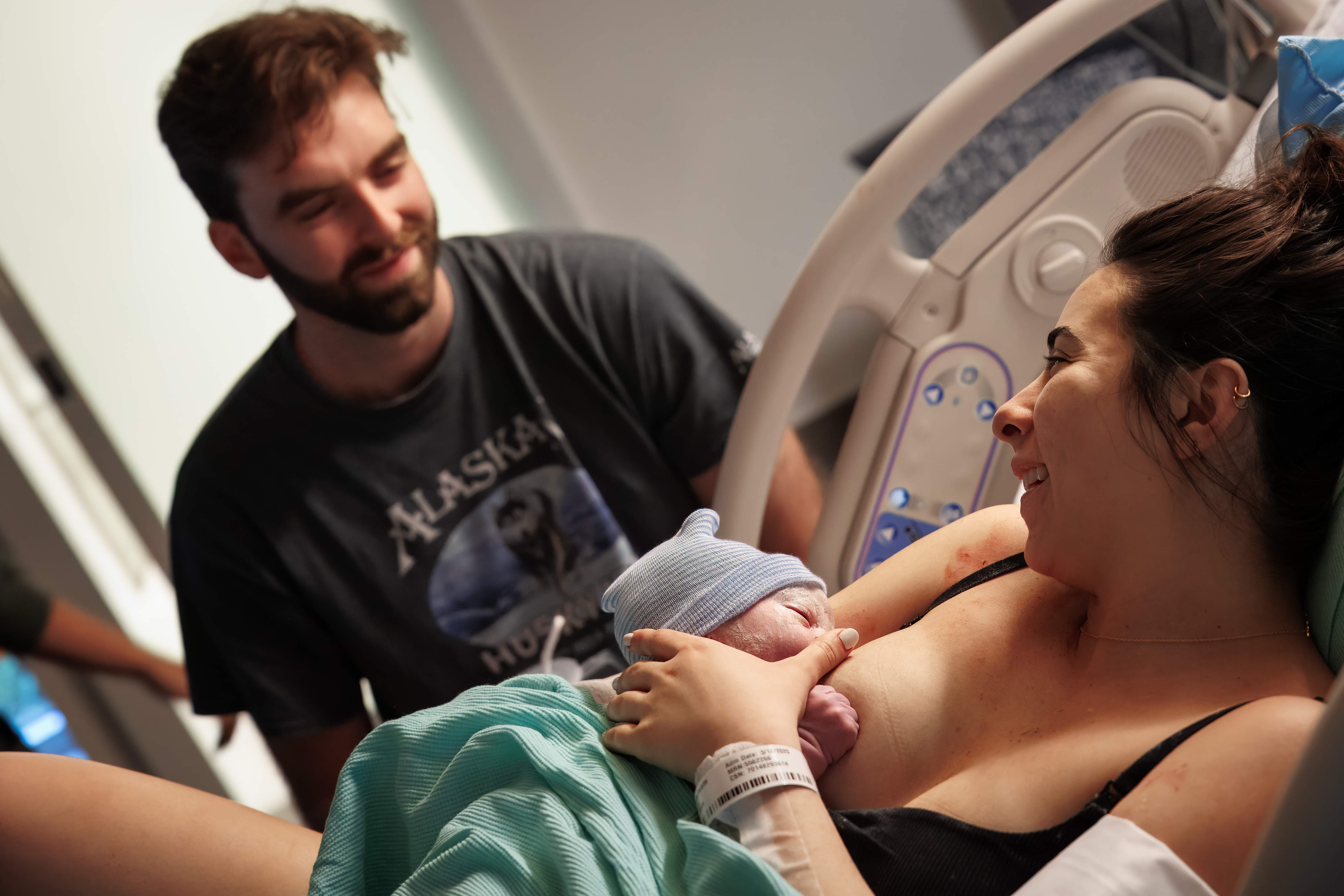Parents beaming during skin-to-skin with their newborn